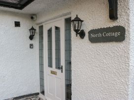 An entrance with a door and light fixtures at North Cottage in Bowness-On-Windermere
