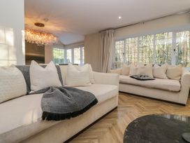 A living room with sofas and a chandelier at North Cottage Bowness-On-Windermere