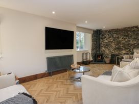 A living room with a television and a fireplace at North Cottage in Bowness-On-Windermere