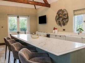 A kitchen with a large island and bar stools at North Cottage Bowness-On-Windermere