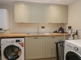 A utility room with a washing machine and sink at North Cottage in Bowness-On-Windermere