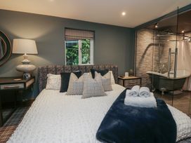 A bedroom with a bed and a bathtub at North Cottage in Bowness-On-Windermere