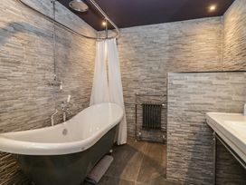 A bathroom with a bathtub, shower, and sink at North Cottage in Bowness-On-Windermere