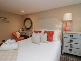 A bedroom with a bed and chair at North Cottage Bowness-On-Windermere