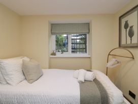 A bedroom with a bed and window at North Cottage in Bowness-On-Windermere
