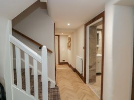 A hallway with staircase and door leading to a bathroom at North Cottage in Bowness-On-Windermere