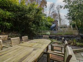 A garden with wooden furniture and a play area at North Cottage in Bowness-On-Windermere