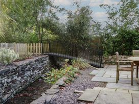 A garden with a bridge over a stream at North Cottage Bowness-On-Windermere