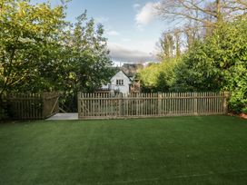 A garden with a fence and play structure at North Cottage in Bowness-On-Windermere