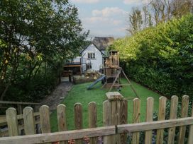 A garden with a playground and a house at North Cottage Bowness-On-Windermere