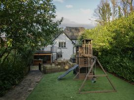 A garden with a playset and outdoor seating at North Cottage in Bowness-On-Windermere