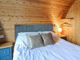 A bedroom with a bed and lamp at Garden Lodge 4 Swansea