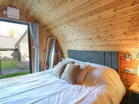 A bedroom with a bed and mirror at Garden Lodge 4 in Swansea