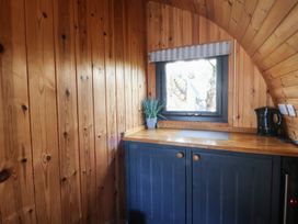 A kitchen with wooden walls and a kettle in Garden Lodge 4 Swansea