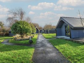 An outdoor area with cabins and a pathway at Garden Lodge 8 in Swansea