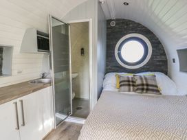 A bedroom with a bed and shower at Garden Lodge 9 in Swansea