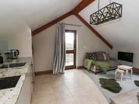 A living room with a sofa and kitchenette at Rose Apartment in Oldwalls near Reynoldston