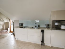 A kitchen with cabinets and appliances at Rose Apartment Oldwalls near Reynoldston