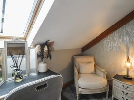 An attic corner with a chair and table at Rose Apartment in Oldwalls near Reynoldston