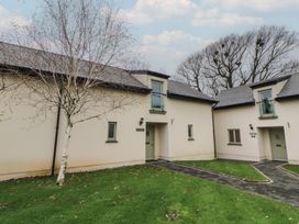 An exterior view of a house with a pathway and tree at Rose Apartment Oldwalls near Reynoldston