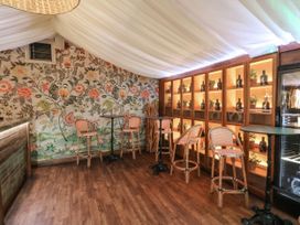 A bar area with stools and a floral wall at Rose Apartment in Oldwalls near Reynoldston