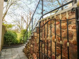 A gated entrance with stone wall and steps at Rose Apartment, Old Walls, Llanrhidian, Gower