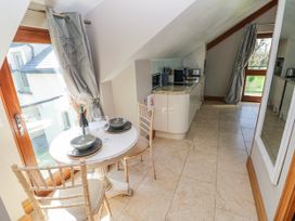 A kitchen with a table and chairs at Rose Apartment, Old Walls, Llanrhidian, Gower