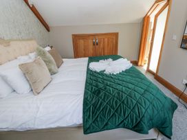 A bedroom with a bed and wardrobe at Rose Apartment in Old Walls, Llanrhidian, Gower