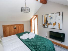 A bedroom with a bed and a door leading outside at Rose Apartment Old Walls, Llanrhidian, Gower