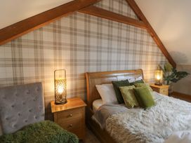 A bedroom with a bed and nightstands at Willow Apartment in Swansea