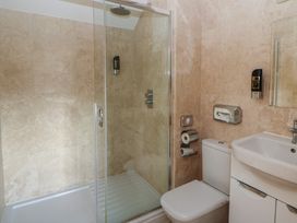 A bathroom with a shower, toilet, and sink at Willow Apartment in Swansea