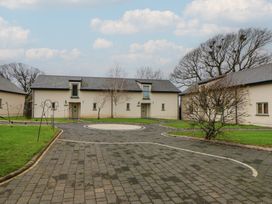 A view of a courtyard with buildings and trees at Willow Apartment in Swansea