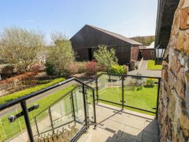An outdoor area with a balcony overlooking buildings at Willow Apartment in Oldwalls, Llanrhidian, Gower