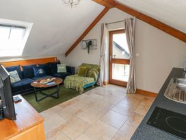 A living room with a sofa and coffee table at Willow Apartment in Oldwalls, Llanrhidian, Gower