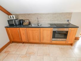 A kitchen with appliances and cabinets at Willow Apartment, Oldwalls, Llanrhidian, Gower