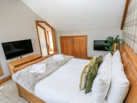 A bedroom with a bed and television at Willow Apartment, Oldwalls, Llanrhidian, Gower