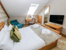 A bedroom with a bed and desk in Willow Apartment, Oldwalls, Llanrhidian, Gower