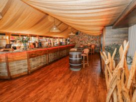 A bar area with a counter and stools at Willow Apartment in Oldwalls, Llanrhidian, Gower
