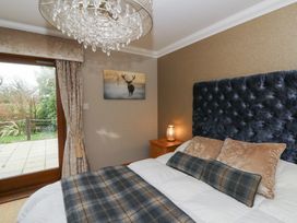 A bedroom with a bed and a bedside table at Ivy Cottage in Swansea