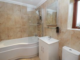 A bathroom featuring a bathtub, shower, sink, and toilet at Ivy Cottage in Swansea