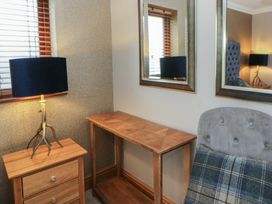 A sitting room with a table and lamp at Ivy Cottage Swansea