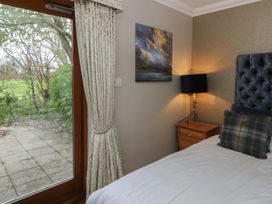 A bedroom with a bed and a bedside table at Ivy Cottage in Swansea