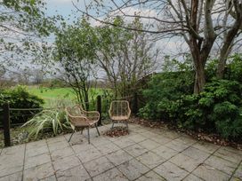 An outdoor area with chairs and plants at Ivy Cottage in Swansea