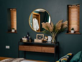 A bedroom with a table and mirror at Ivy Cottage Oldwalls near Reynoldston