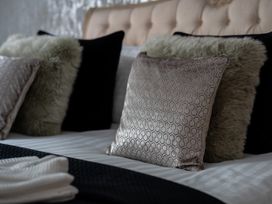 A bed with decorative pillows at Ivy Cottage in Oldwalls near Reynoldston