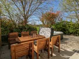 An outdoor area with a wooden table and chairs at Ivy Cottage Oldwalls, Llanrhidian, Gower