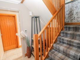 A hallway with stairs and a door at Ivy Cottage, Oldwalls, Llanrhidian, Gower