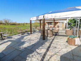 An outdoor seating area with wicker chairs and tables at Ivy Cottage, Oldwalls, Llanrhidian, Gower