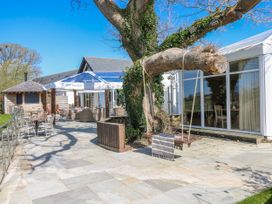 An outdoor area with a swing and seating at Ivy Cottage in Oldwalls, Llanrhidian, Gower