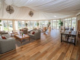 A conservatory with sofas and tables at Ivy Cottage, Oldwalls, Llanrhidian, Gower